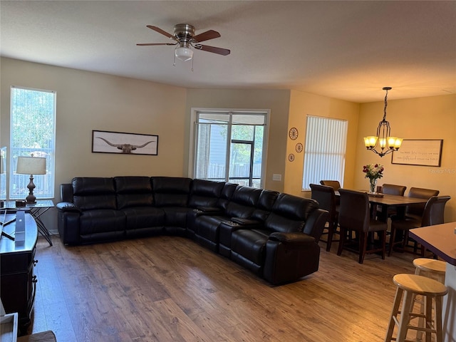 living area featuring wood finished floors, a chandelier, and a ceiling fan