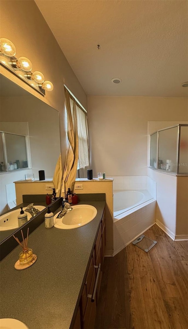 full bath with wood finished floors, a shower stall, a garden tub, and vanity