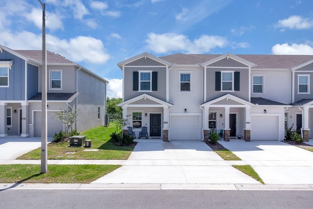 townhome / multi-family property featuring a garage, concrete driveway, stucco siding, and stone siding
