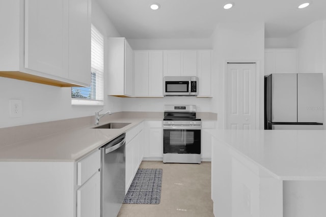 kitchen with appliances with stainless steel finishes, a sink, white cabinets, recessed lighting, and light countertops