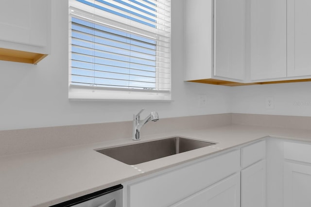kitchen featuring a sink, light countertops, white cabinetry, and stainless steel dishwasher