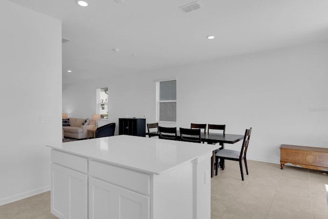 kitchen with white cabinetry, light countertops, a kitchen island, recessed lighting, and open floor plan