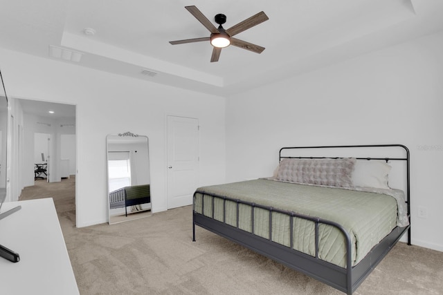 bedroom with carpet, a tray ceiling, baseboards, and ceiling fan