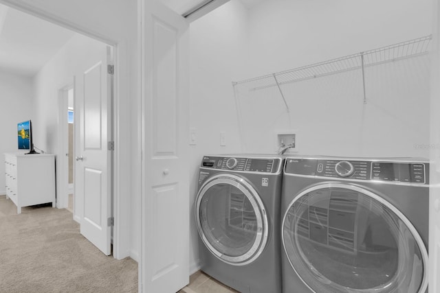 washroom with washing machine and dryer and light carpet