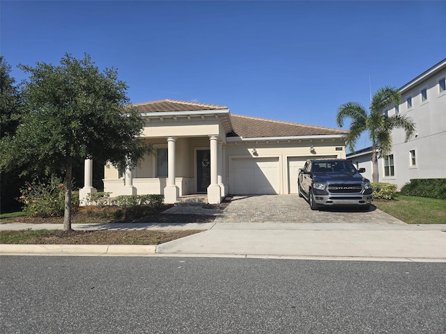 8270 Topsail Pl, Winter Garden, FL 34787 - view of front of home featuring decorative driveway, a garage, stucco siding, and a tile roof