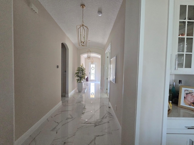8270 Topsail Pl, Winter Garden, FL 34787 - hall featuring arched walkways, a textured ceiling, and light marble finish floors