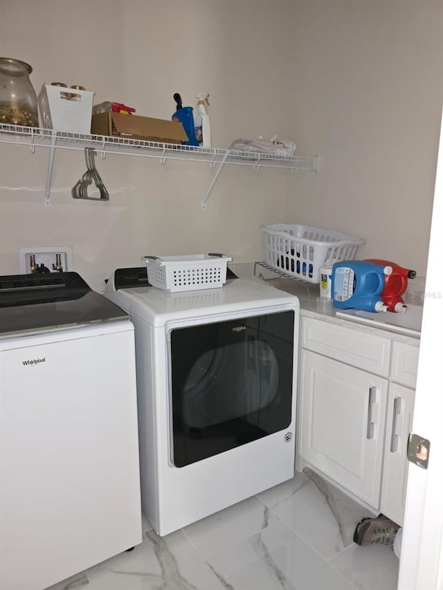 8270 Topsail Pl, Winter Garden, FL 34787 - laundry area featuring washing machine and clothes dryer, light marble finish flooring, and cabinet space