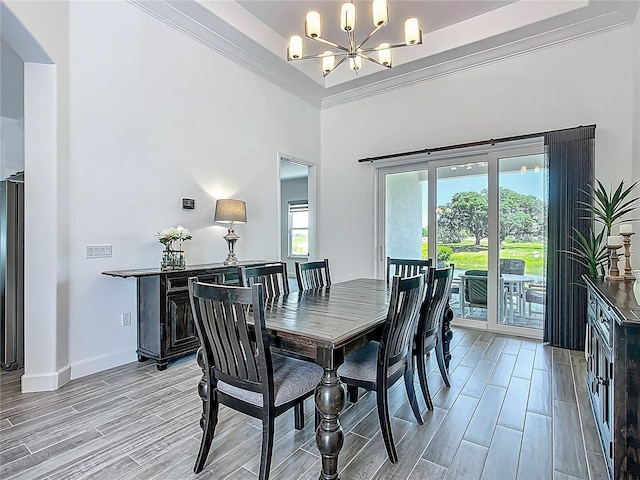 dining space with a chandelier, wood finish floors, ornamental molding, and baseboards