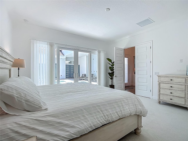 bedroom featuring access to exterior, carpet floors, french doors, and a textured ceiling