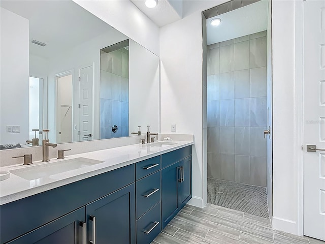 bathroom with a walk in shower, double vanity, and baseboards