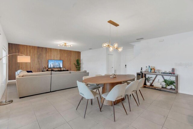 374 Pine Tree Bridge Trl, Saint Cloud, FL 34772 - dining space featuring a chandelier, an accent wall, wood walls, and light tile patterned flooring