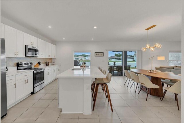 374 Pine Tree Bridge Trl, Saint Cloud, FL 34772 - kitchen featuring appliances with stainless steel finishes, a sink, tasteful backsplash, light countertops, and recessed lighting