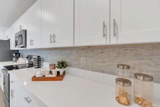 374 Pine Tree Bridge Trl, Saint Cloud, FL 34772 - kitchen featuring appliances with stainless steel finishes, light countertops, white cabinets, and tasteful backsplash