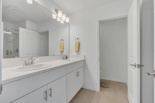 374 Pine Tree Bridge Trl, Saint Cloud, FL 34772 - full bathroom featuring toilet, double vanity, a shower with shower door, tile patterned floors, and baseboards