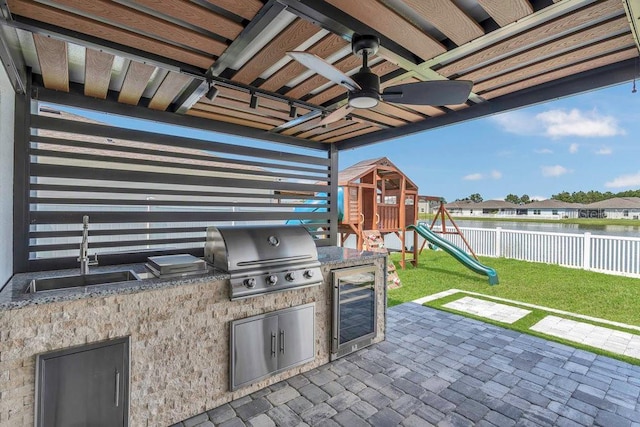 374 Pine Tree Bridge Trl, Saint Cloud, FL 34772 - view of patio / terrace with a grill, a sink, beverage cooler, a water view, and an outdoor kitchen