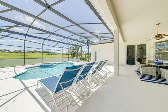 view of pool with a patio area, a ceiling fan, a pool with connected hot tub, and a lanai