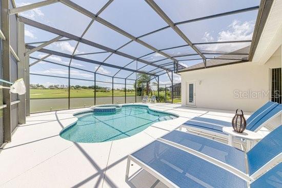 view of pool with a patio area, a pool with connected hot tub, and a lanai