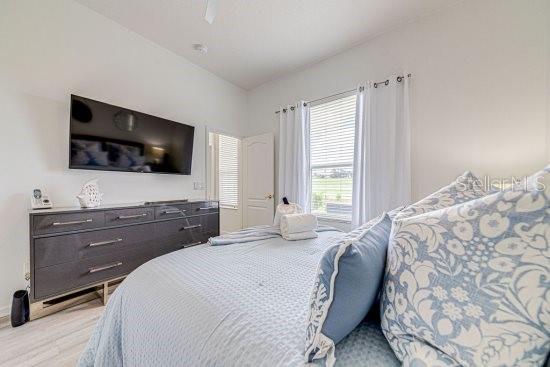 bedroom with light wood-style floors and a ceiling fan