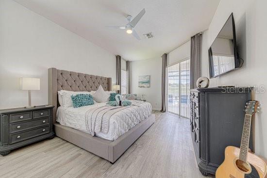 bedroom with wood finished floors, access to exterior, a ceiling fan, and baseboards