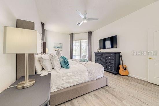bedroom featuring wood finished floors, a ceiling fan, and baseboards