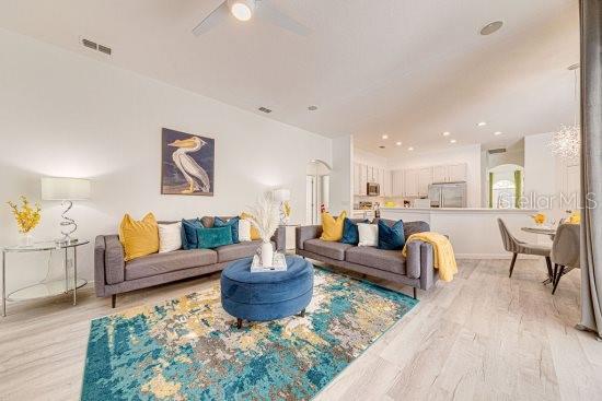 living area featuring light wood-type flooring and ceiling fan