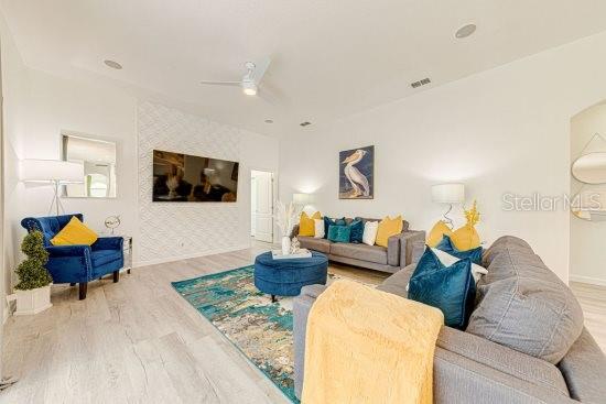 living room with wood finished floors, baseboards, and a ceiling fan