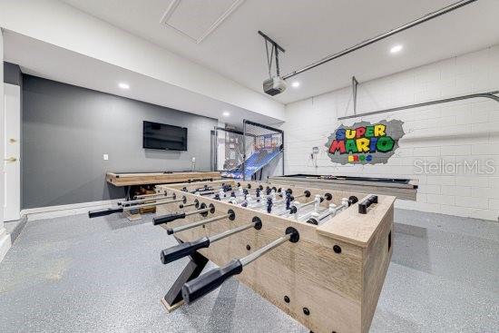 playroom featuring a garage, recessed lighting, and speckle patterned floor