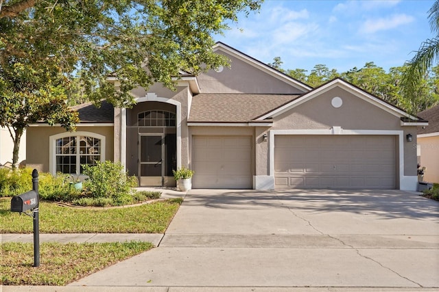 view of front facade featuring a garage, stucco siding, and driveway