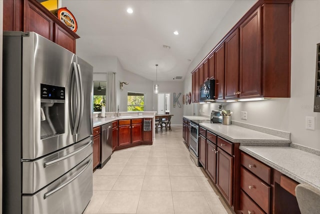 kitchen featuring appliances with stainless steel finishes, a peninsula, lofted ceiling, light countertops, and a sink