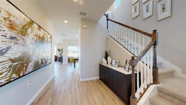 stairway with wood finished floors, recessed lighting, and baseboards