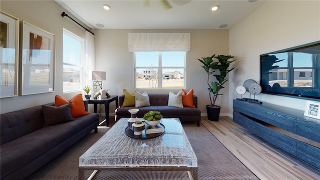 living area with wood finished floors, plenty of natural light, recessed lighting, and baseboards