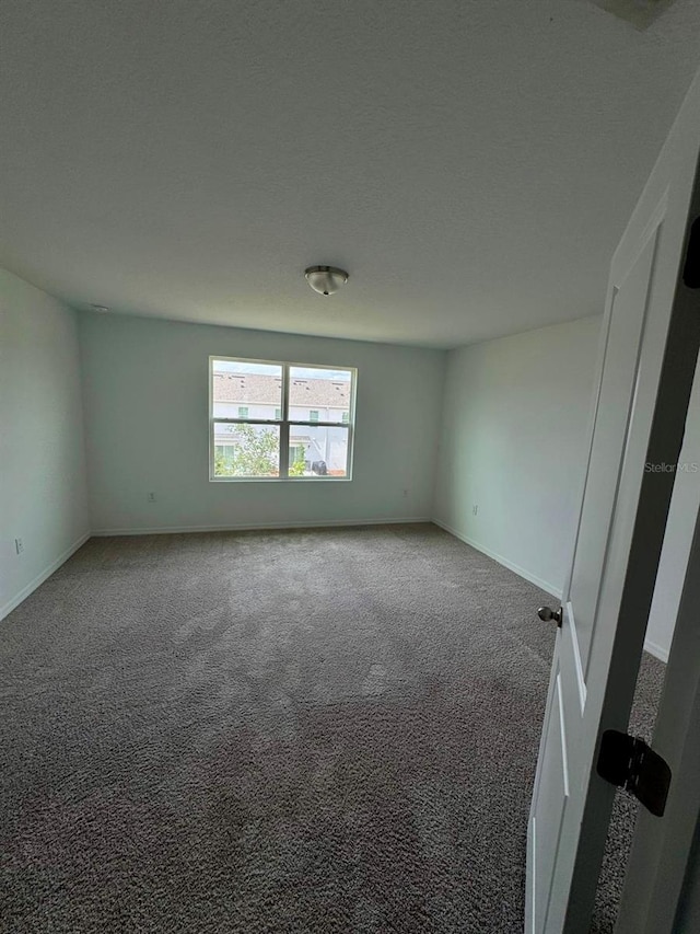 unfurnished room with carpet flooring and baseboards