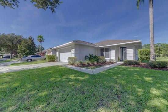 2908 Sunset Lakes Blvd, Kissimmee, FL 34747 - ranch-style home with a garage, a front yard, and driveway