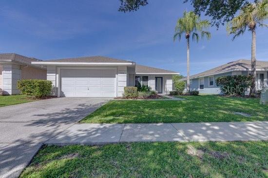 2908 Sunset Lakes Blvd, Kissimmee, FL 34747 - ranch-style home featuring a garage, a front lawn, and concrete driveway