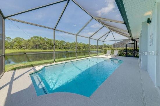 2908 Sunset Lakes Blvd, Kissimmee, FL 34747 - outdoor pool featuring a water view, a patio, and glass enclosure