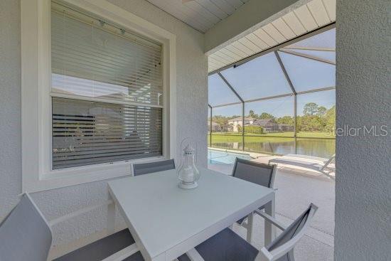 2908 Sunset Lakes Blvd, Kissimmee, FL 34747 - view of patio featuring a water view, an outdoor pool, a lanai, and outdoor dining area