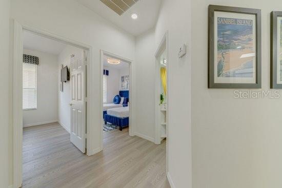 2908 Sunset Lakes Blvd, Kissimmee, FL 34747 - hall with light wood-style floors and baseboards