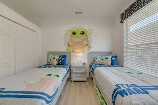 2908 Sunset Lakes Blvd, Kissimmee, FL 34747 - bedroom featuring wood finished floors and a closet