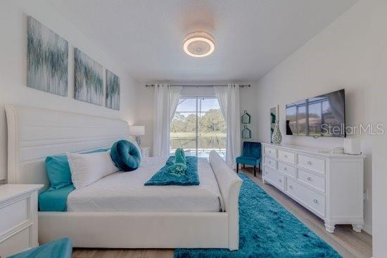 2908 Sunset Lakes Blvd, Kissimmee, FL 34747 - bedroom with wood finished floors and access to outside