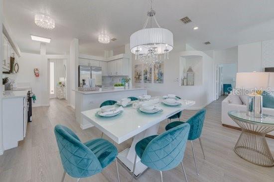 2908 Sunset Lakes Blvd, Kissimmee, FL 34747 - dining space featuring light wood-type flooring and a chandelier