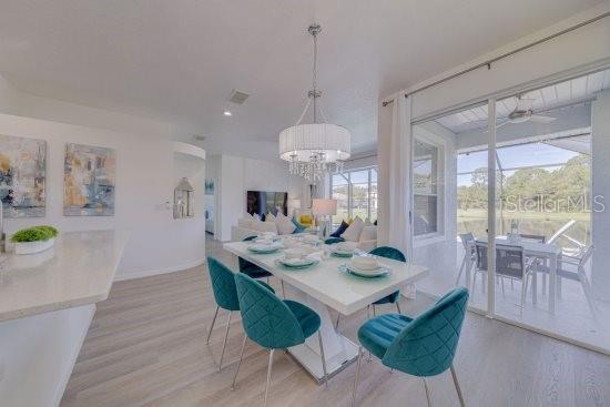 2908 Sunset Lakes Blvd, Kissimmee, FL 34747 - dining space featuring light wood finished floors, a chandelier, a ceiling fan, and baseboards