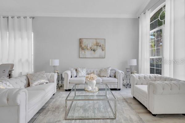 721 Hardwood Cir, Orlando, FL 32828 - living room featuring ornamental molding and light wood-type flooring