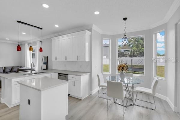 721 Hardwood Cir, Orlando, FL 32828 - kitchen with a sink, a peninsula, recessed lighting, ornamental molding, and light countertops