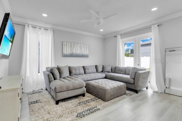 721 Hardwood Cir, Orlando, FL 32828 - living area featuring crown molding, light wood-style floors, recessed lighting, ceiling fan, and baseboards