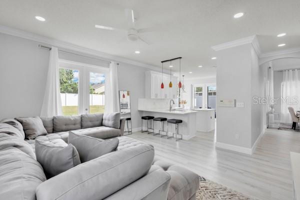 721 Hardwood Cir, Orlando, FL 32828 - living area with crown molding, ceiling fan, baseboards, recessed lighting, and light wood finished floors