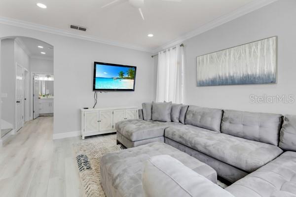 721 Hardwood Cir, Orlando, FL 32828 - living room with wood finished floors, arched walkways, crown molding, recessed lighting, and ceiling fan