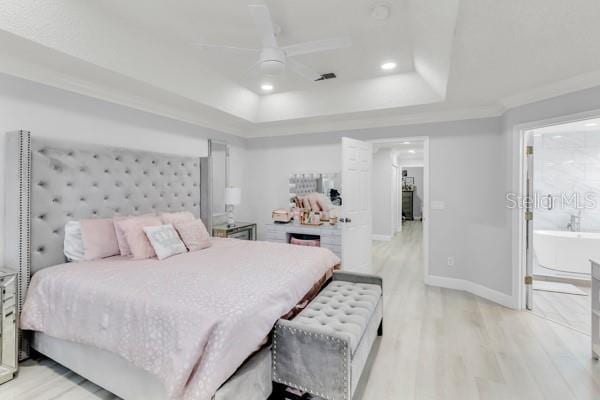 721 Hardwood Cir, Orlando, FL 32828 - bedroom featuring a raised ceiling, light wood-style flooring, recessed lighting, connected bathroom, and baseboards