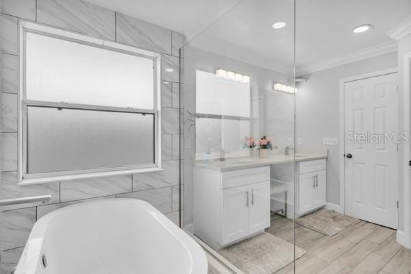 721 Hardwood Cir, Orlando, FL 32828 - bathroom with vanity, crown molding, a soaking tub, wood finished floors, and recessed lighting