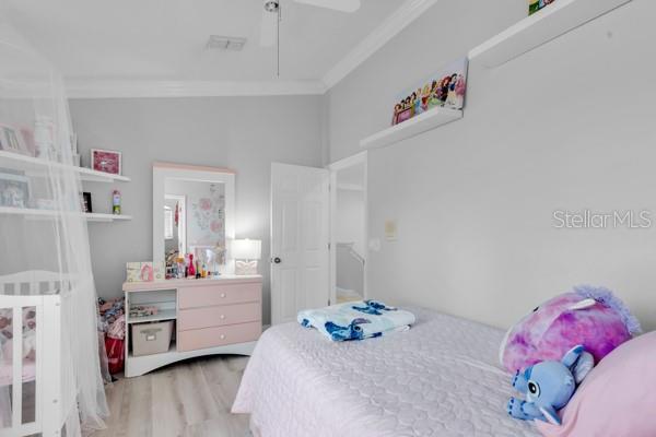 721 Hardwood Cir, Orlando, FL 32828 - bedroom featuring crown molding, wood finished floors, and a ceiling fan
