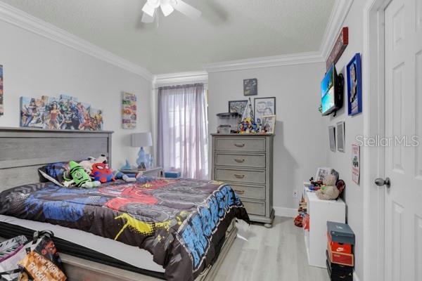 721 Hardwood Cir, Orlando, FL 32828 - bedroom with crown molding, wood finished floors, baseboards, and ceiling fan